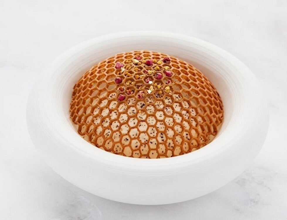 Honeycomb tuile dome over a speckled cream dessert finished with rose petals and pollen